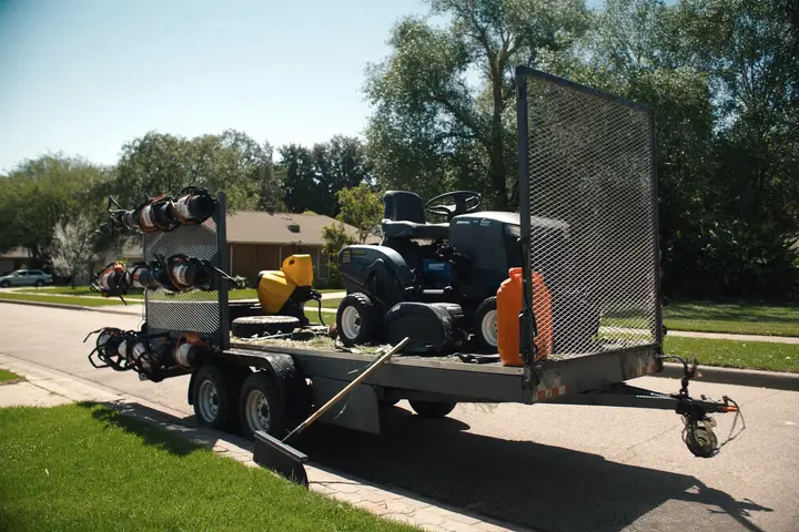 Mowers and trimmers loaded on an equipment trailer.